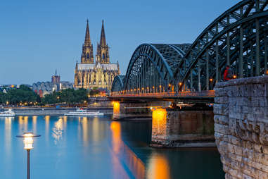 view of lighted cologne cathedral next to hohenzollern bridge 
